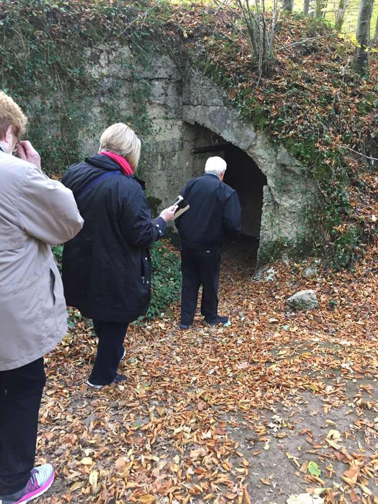 Three members of the tour group lined up outside the entrance to a bunker